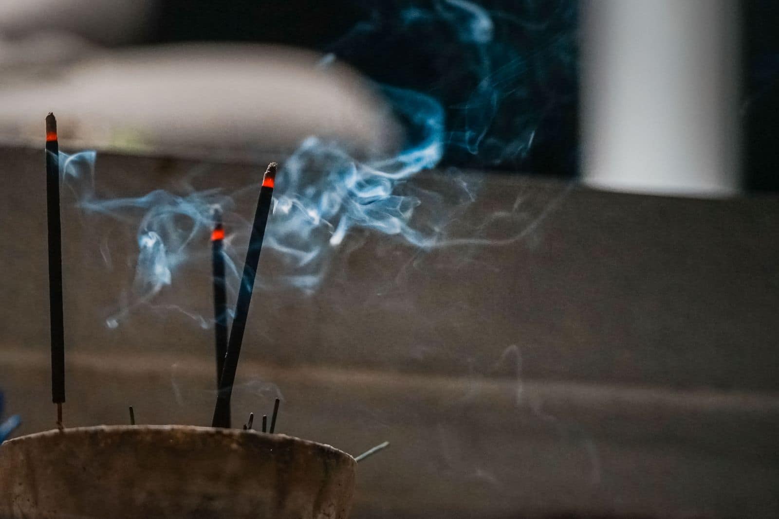 Two incense sticks burning with rising smoke