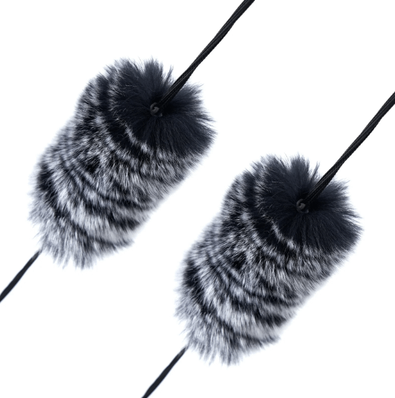 A pair of fur string silencers installed on a bowstring, reducing vibration and noise for a quieter shot.