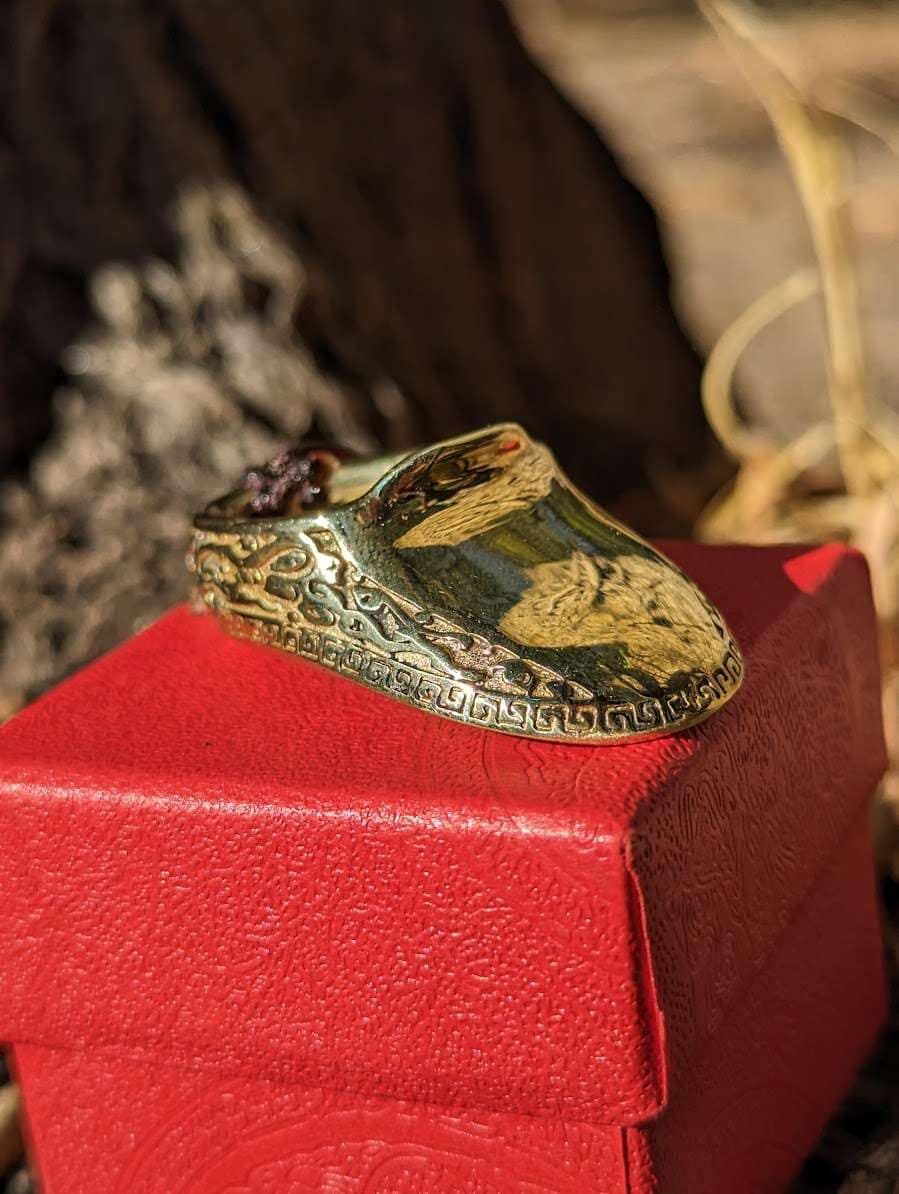 Traditional brass ring seen from the side, with the flared lip that guards the thumb
