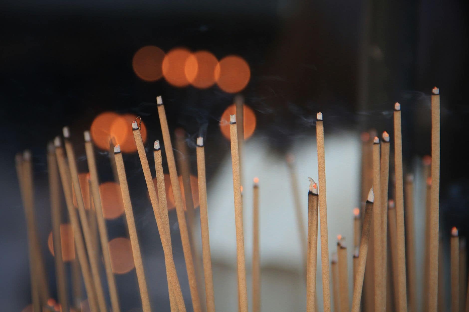 Natural incense sticks burning with glowing tips and soft, clean smoke