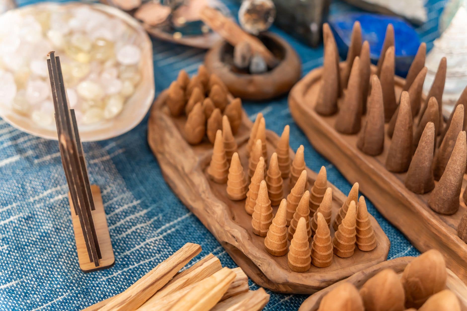 Different types of incense side by side โ hand-rolled sticks and cones on a wooden tray
